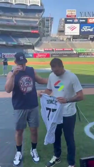 東契奇接過紐約洋基隊球星阿隆-賈奇贈送的洋基隊77號球衣