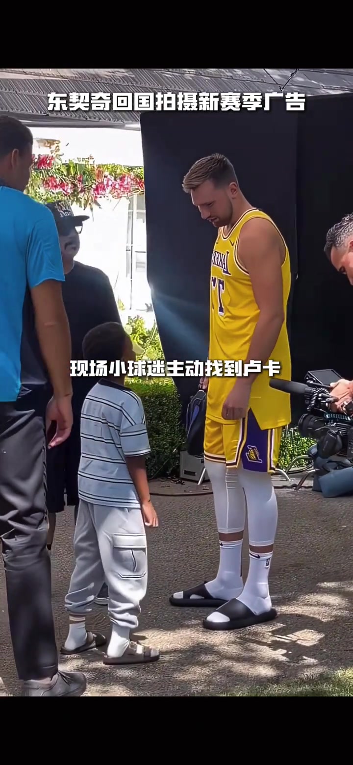 備戰(zhàn)新賽季東契奇回國(guó)拍攝廣告 身穿湖人77號(hào)和小球迷合影